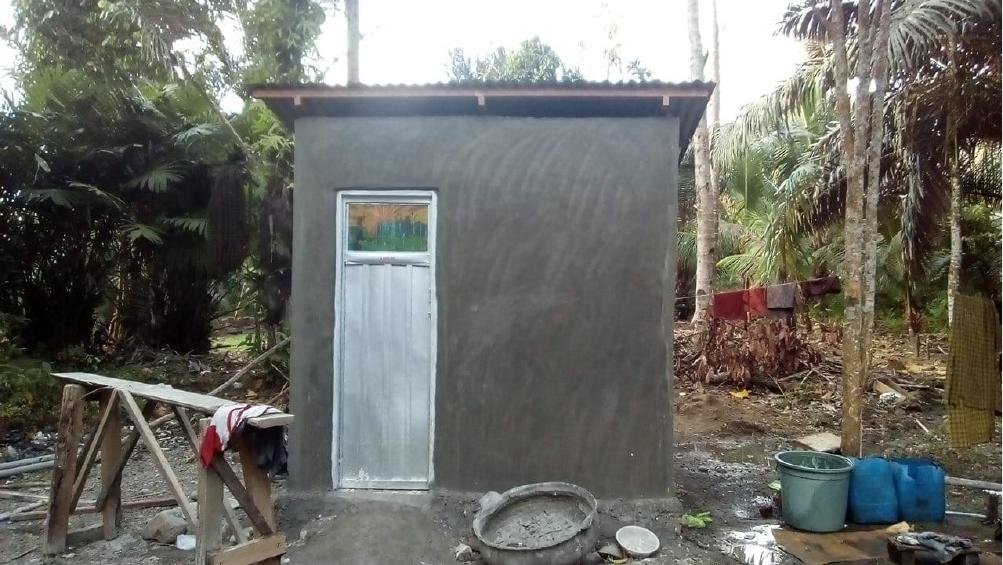 A completed Mbuwu toilet block, exterior view, surrounded by tropical plants