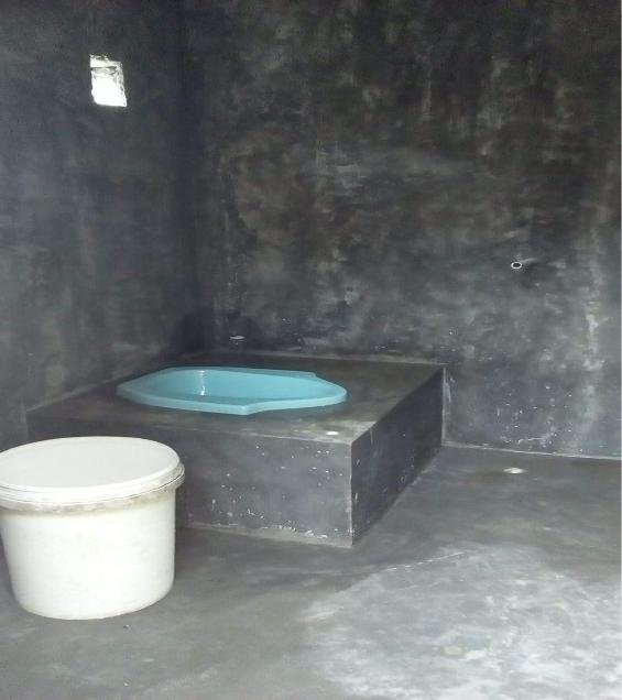 Inside one of the Mbuwu toilets, showing the built-in concrete water basin used for washing