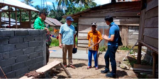 The Waterjars and Entrust team meeting with the Mbuwu community at a partially-built toilet site
